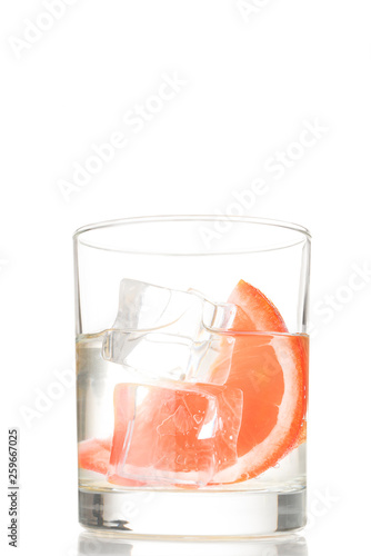 glass of water with ice and grapefruit or sicilian orange, isolated on white background. Non alcoholic cocktail