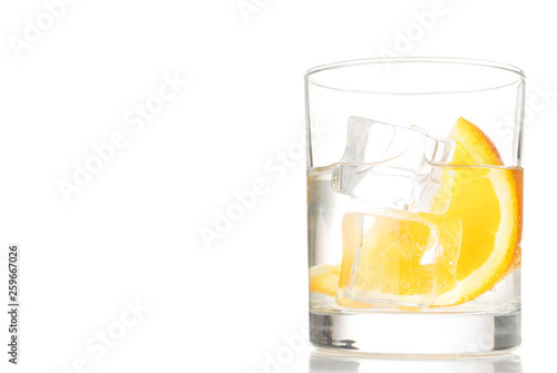Summer cocktal with water, ice and orange slice, isolated, copy space. White background