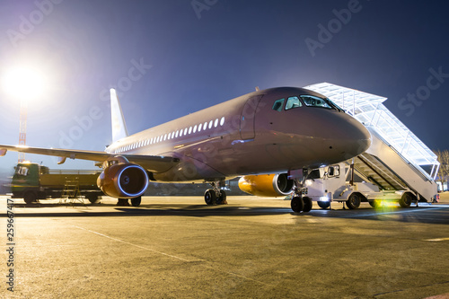White passenger jet plane with boarding steps at the night airport apron © Dushlik