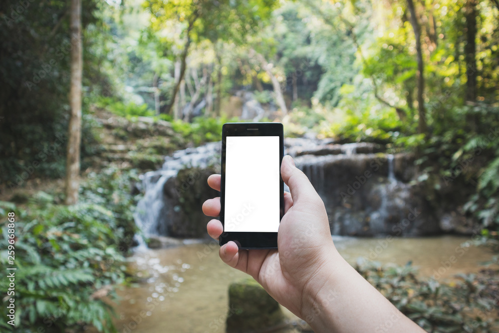 hand holding black smartphone Have space to enter text with white screen at isolated background With a blurred waterfall background hand holding black smartphone Have space to enter text with white screen at isolated background With a blurred waterfall background