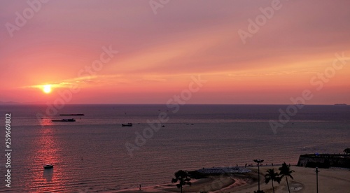 Ocean sunset boat silhouette is boat sailing along the ocean water with a colorful vivid sunset sky