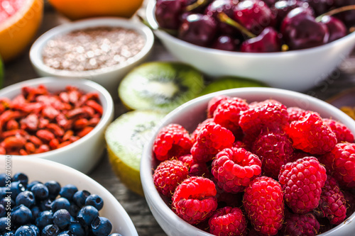 Healthy food. Organic fresh raspberry and variety fruit on table.