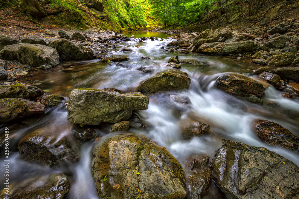 Scenic view of amazing water motion blur of a water stream between rocks. Scenic view of amazing water motion blur of a water stream between rocks.