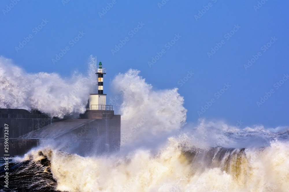 Stormy wave over lighthouse of San Esteban de Pravia.