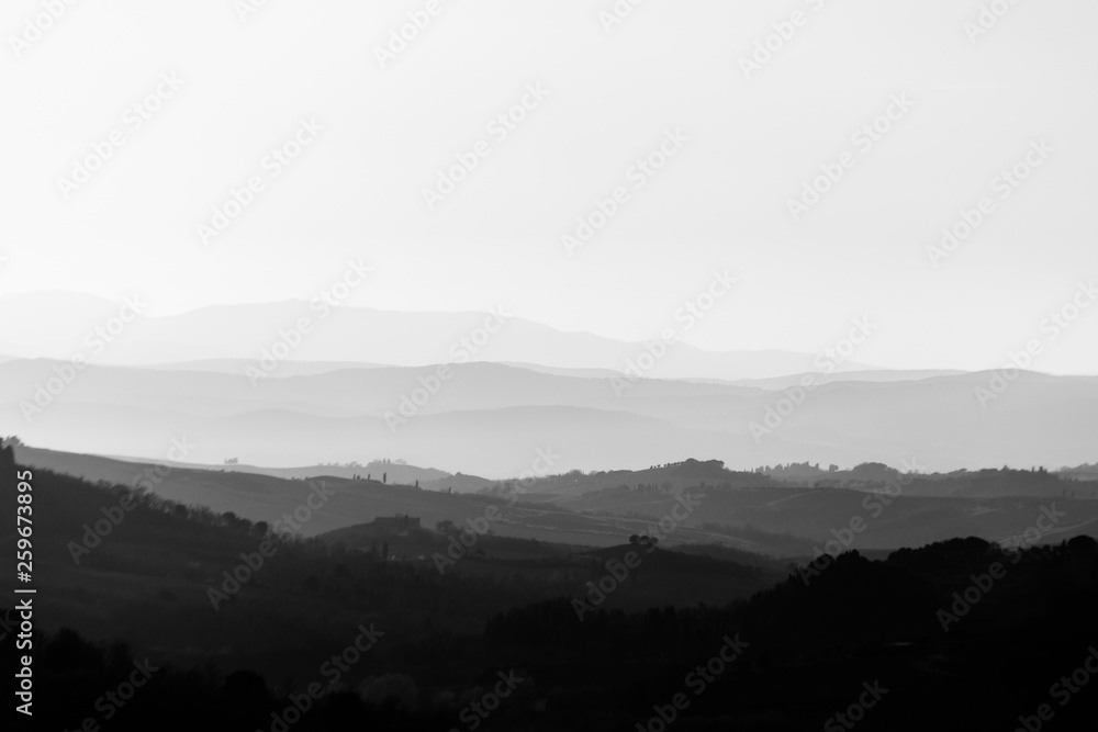 Beautiful view of Tuscany hills at sunset with mist