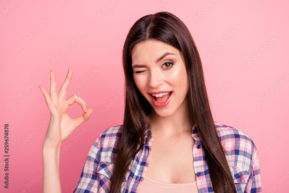 Close up photo amazing her she lady hold arm hand fingers okey symbol winking brown eyes long straight hair wear casual checkered plaid shirt clothes outfit isolated pink bright background Close up photo amazing her she lady hold arm hand fingers okey symbol winking brown eyes long straight hair wear casual checkered plaid shirt clothes outfit isolated pink bright background