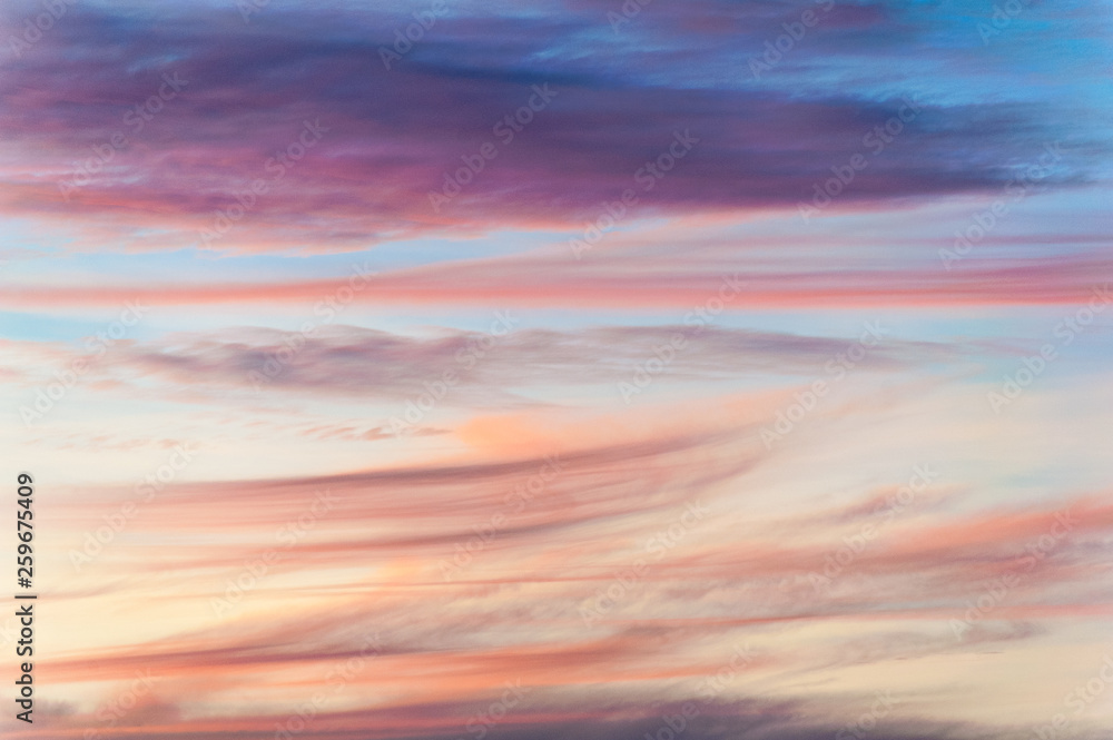 Colorful clouds with different shapes in the sky with pinks, reds and purples like a painting's brush strokes