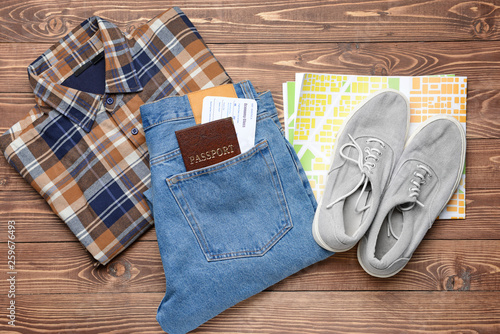 Male clothes with documents and map on wooden background
