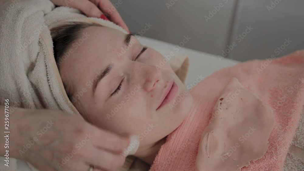 A professional cosmetologist rubs the girl's face with special moisturizing wipes. New concept in cosmetology. A professional cosmetologist rubs the girl's face with special moisturizing wipes. New concept in cosmetology.