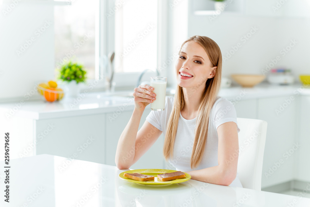 Portrait of her she nice-looking cute charming lovely attractive winsome cheerful straight-haired girl wearing white having good beverage lunch in light white interior room