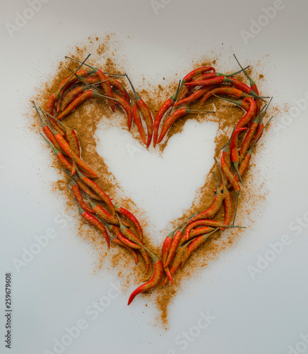 Close-up of Heart, symbol of love, designed from red hot chili cayenne peppers handful with paprica powder
