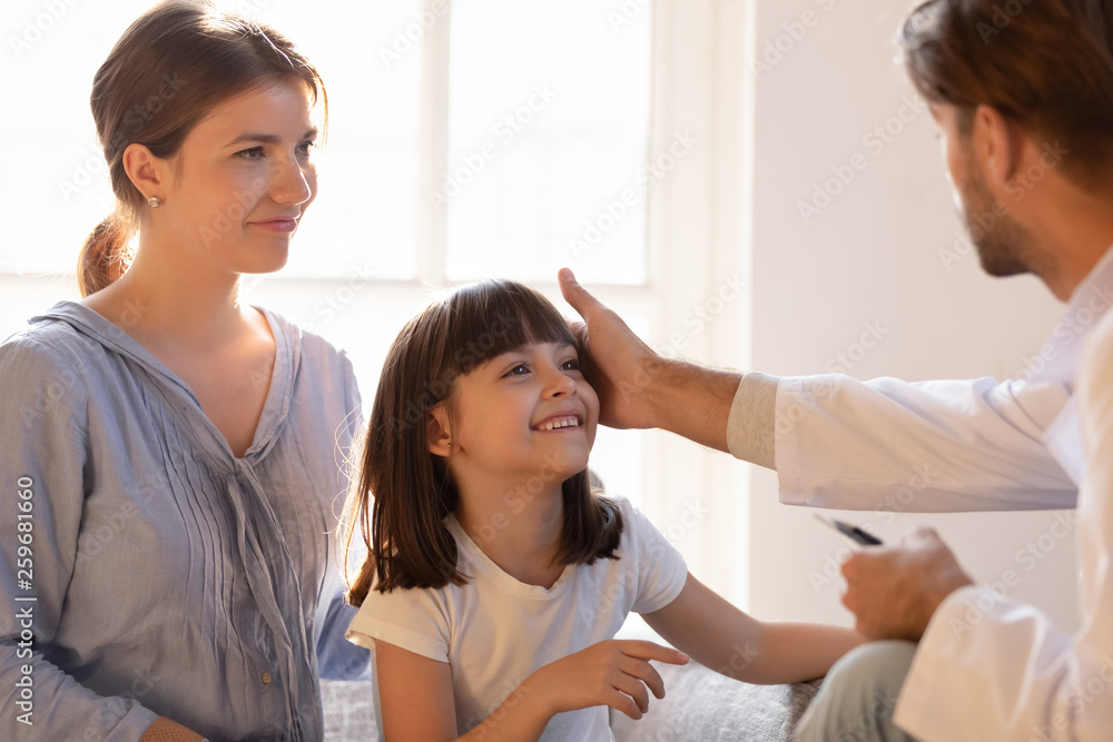 Paediatrician stroking patient girl encourages her before medical examination Paediatrician stroking patient girl encourages her before medical examination