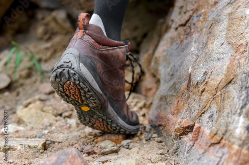 Hiking trip concept, close-up shot of a legs with trekking shoes in the mountain