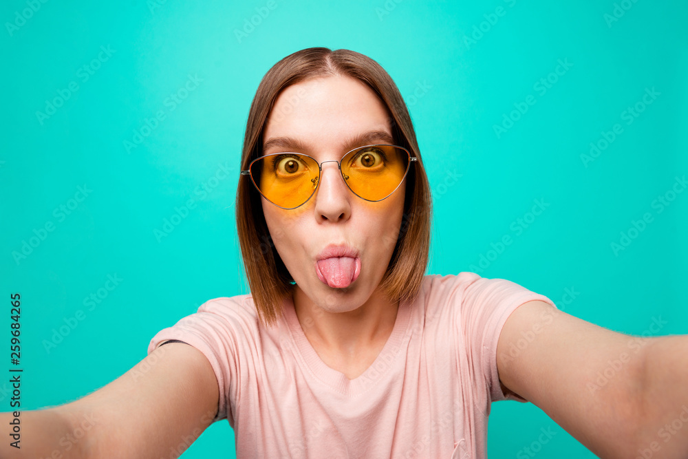 Close up photo beautiful her she lady modern look short straight hair make take selfies instagram post followers tongue out mouth careless wear specs casual t-shirt isolated teal turquoise background Close up photo beautiful her she lady modern look short straight hair make take selfies instagram post followers tongue out mouth careless wear specs casual t-shirt isolated teal turquoise background