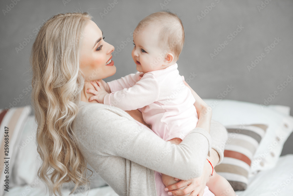 Young mother with her little cute baby daughter. Little baby girl and her mom. Mama with her child indoor. Young mother with her little cute baby daughter. Little baby girl and her mom. Mama with her child indoor.
