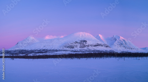 The famous mountain Ahkka, sometimes called the queen of Lapland, in the last sunlight of a winters day. Lapland, Sweden. photo