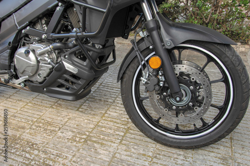 Rueda delantera de una moto donde se observa la horquilla y el freno de disco.