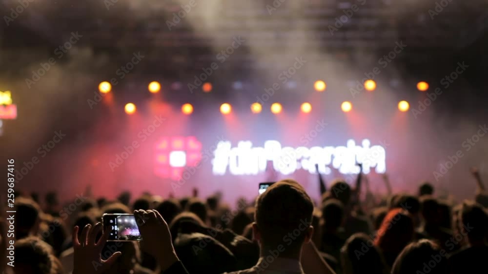 Filming on a smartphone at a country rock music festival. Band leaving the stage while people applaud. Filming on a smartphone at a country rock music festival. Band leaving the stage while people applaud.