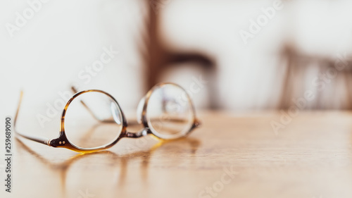 brown glasses on wooden desk with beautiful reflection, copy space on right for product montage