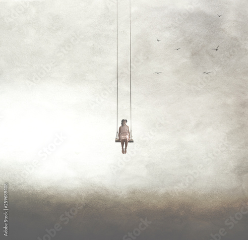 surreal image of a woman on a swing suspended in the sky photo