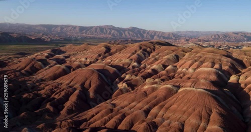 Flying over the red, colorful, rainbow mountains, covered with unique patterns, Iran. Aerial photography.