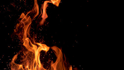 MACRO: Beautiful bright orange flames flicker in the darkness of the night.