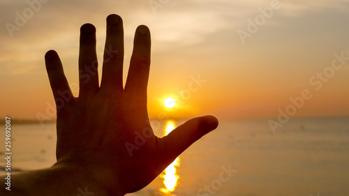 Dawn on the sea and hand palm