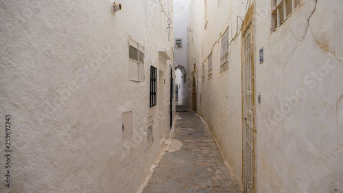 narrow passage between the walls of houses