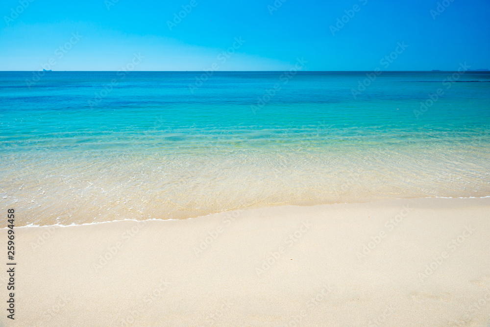 Beautiful horizon view of tropical sea and sand beach under blue sky