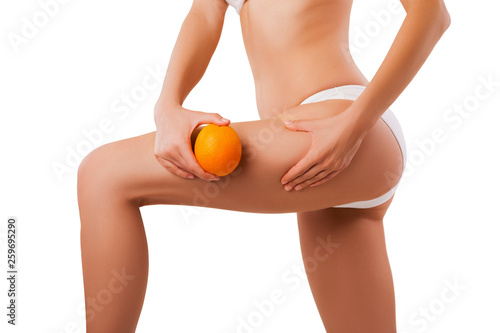 Portrait Close-up Body, weightloss, diet and the fight against cellulite. Cropped photo woman's hips and abdomen with orange in hand. isolated. Studio shot. 