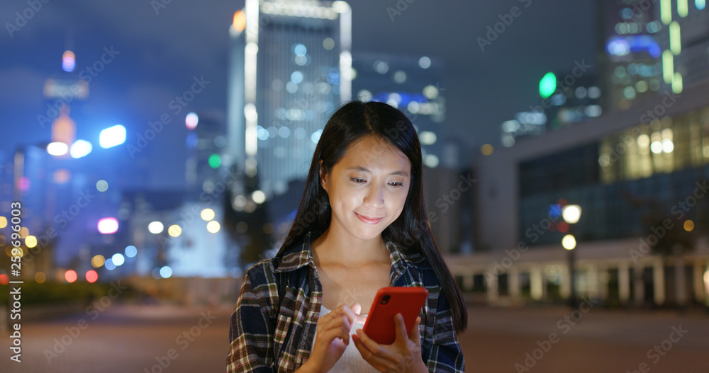 Woman search on cellphone in city at night Woman search on cellphone in city at night