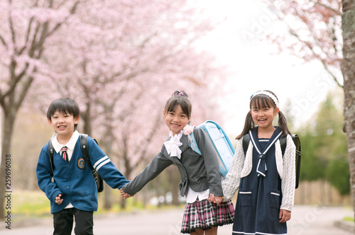桜並木道で微笑む小学生