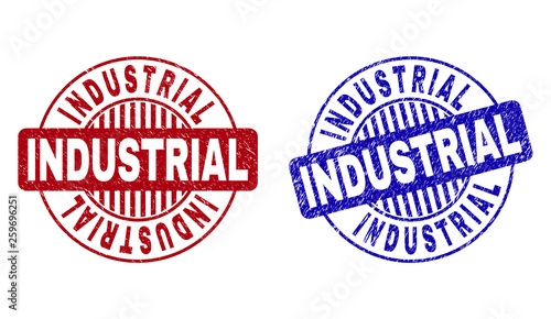 Grunge INDUSTRIAL round watermarks isolated on a white background. Round seals with grunge texture in red and blue colors. Vector rubber imprint of INDUSTRIAL label inside circle form with stripes.