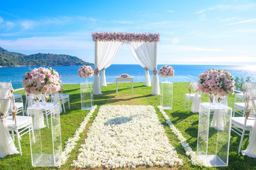 Wedding ceremony. Arch, decorated with flowers on the lawn, beach background, sea in summer.