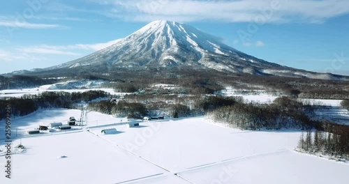 Aerial view of a large mountain in a snow covered landscape