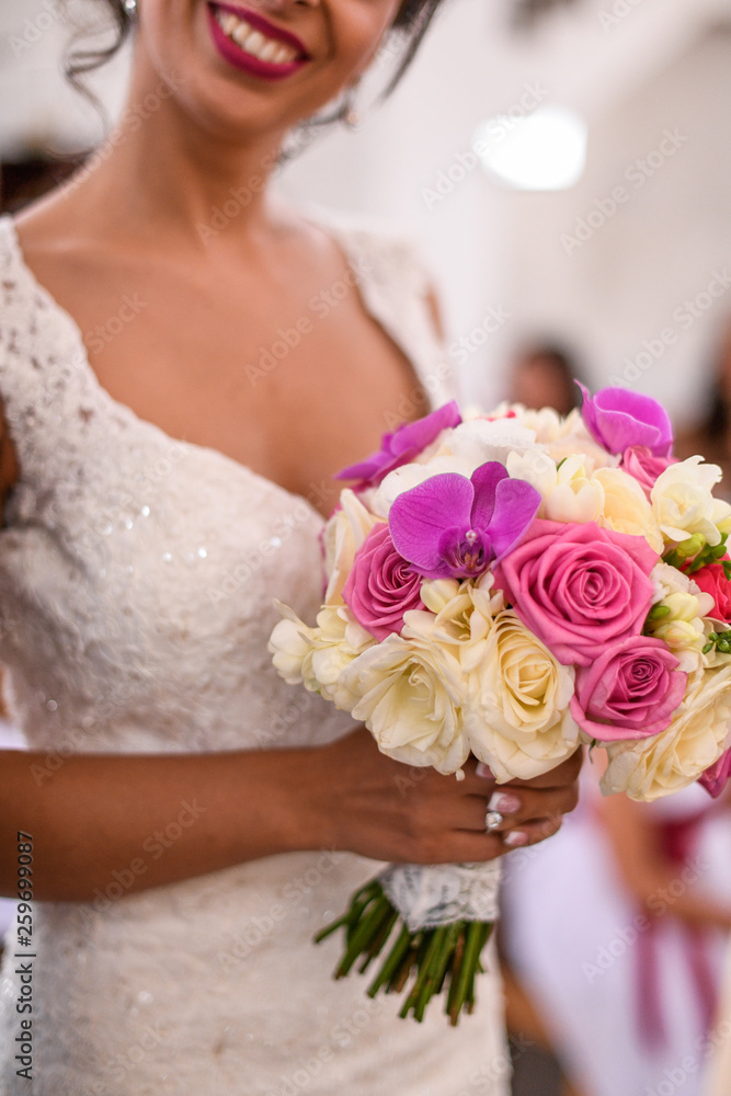 Naklejka premium Brinde in wedding dress posing with bouquet of flowers in hands