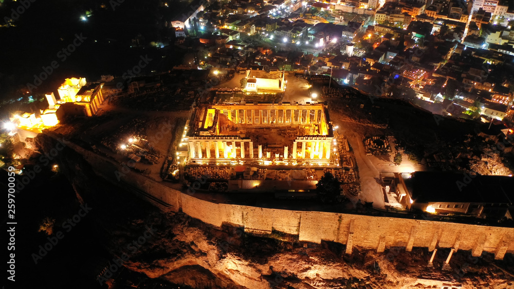Aerial drone night shot of iconic illuminated landmark Acropolis hill and the Masterpiece of Ancient times and Western civilisation - the Parthenon, Athens historic centre, Attica, Greece