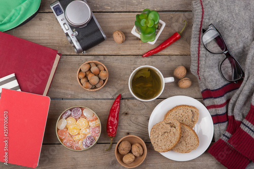 travel concept - cup of tea, sweater, camera, book, eyeglasses, vegetables, nuts, kitchen accessories, candies