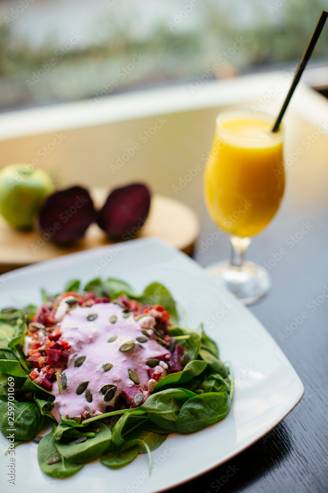 Salad with orange juice beside. 