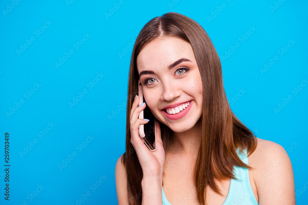 Close up photo beautiful amazing she her lady toothy hold hands arms telephone smart phone look side empty space tell foreign boyfriend wear casual tank top outfit clothes isolated blue background Close up photo beautiful amazing she her lady toothy hold hands arms telephone smart phone look side empty space tell foreign boyfriend wear casual tank top outfit clothes isolated blue background