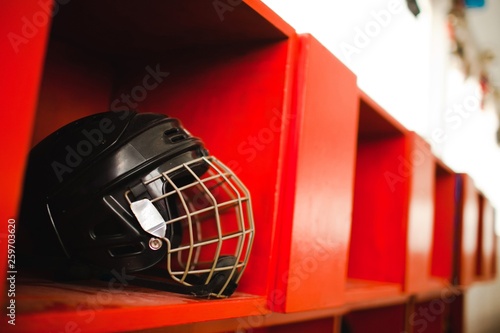 Canvas Print Black hockey protection helmet with cage on red shelf