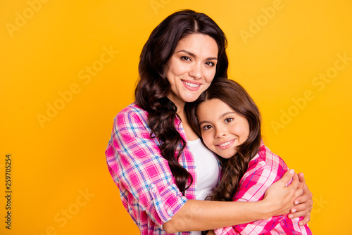 Close up photo two people funny brown haired she her ladies mum small little daughter hold each other hands arms close lovely wear casual pink checkered plaid shirts isolated yellow background