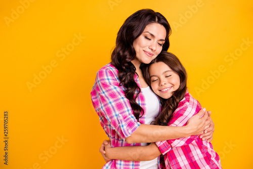 Close up photo two people funny brown haired she her ladies mum mommy small little daughter hold each other hands arms close lovely wear casual pink checkered plaid shirts isolated yellow background