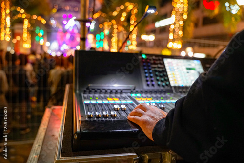 Profesional mixing lights outdoor at carnival party in winter vacation  -  His  hand playing mixing light for people in carnival party - Event, music and fun concept - Focus on left hand - Image