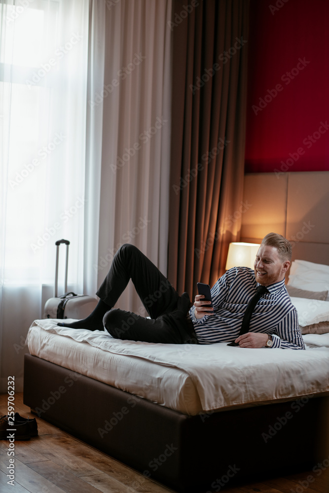Businessman relaxing after meetings. Man checking his wifi connection at a hotel room.
