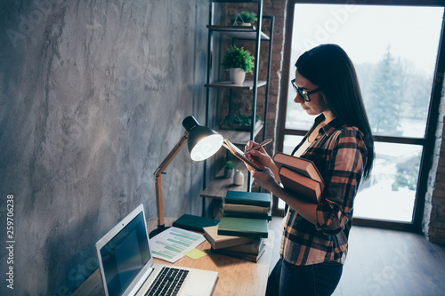 Profile side view of nice attractive charming brunette lady wearing checked shirt creating genius finance plan report review at industrial loft style interior work place station indoors