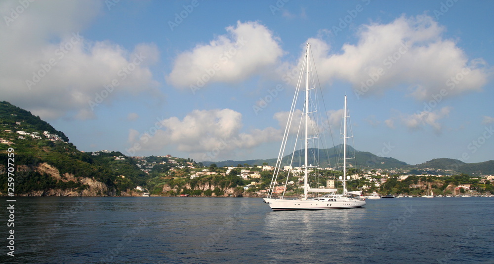View of the southern coast of the beautiful Italian island of Ischia. Villas crowd the shore and boats anchor offshore. View of the southern coast of the beautiful Italian island of Ischia. Villas crowd the shore and boats anchor offshore.