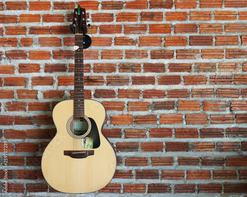 Acoustic guitar with brick wall background © Jittima