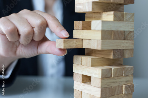 Planning, risk and strategy in business, businessman and engineer gambling placing wooden block on a tower.