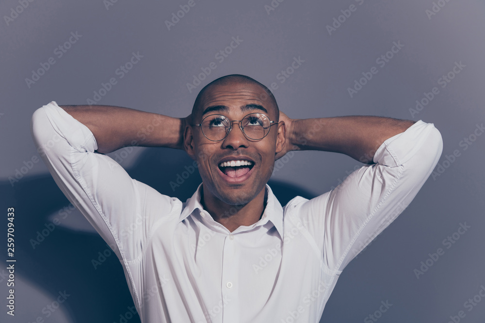 Close up photo amazing stunning dark skin he him his macho arms hands behind head perfect good mood satisfied look up empty space refreshed shaved face wear specs white shirt isolated grey background Close up photo amazing stunning dark skin he him his macho arms hands behind head perfect good mood satisfied look up empty space refreshed shaved face wear specs white shirt isolated grey background